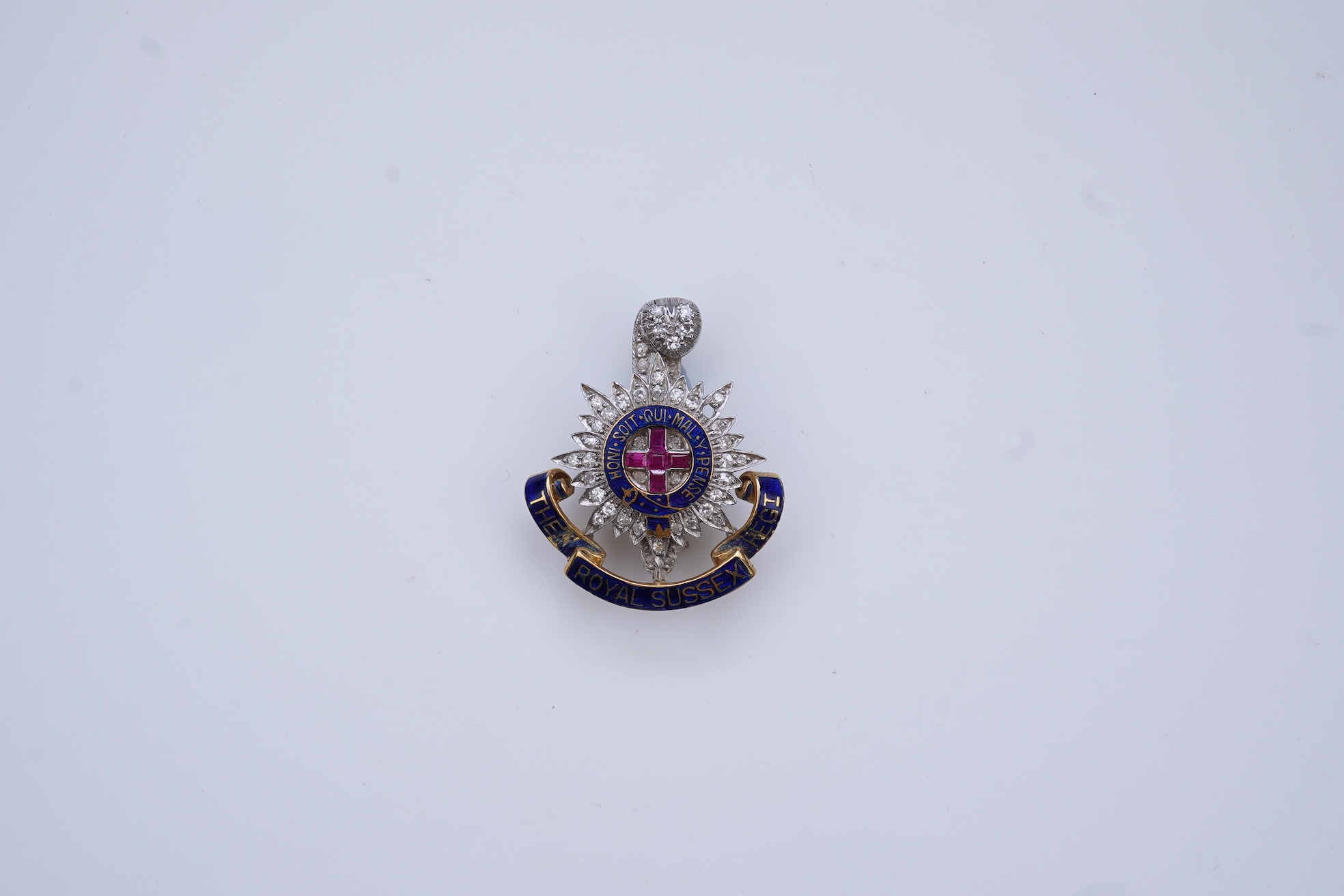 A ruby, enamel and diamond Royal Sussex Regiment badge, mid 20th century